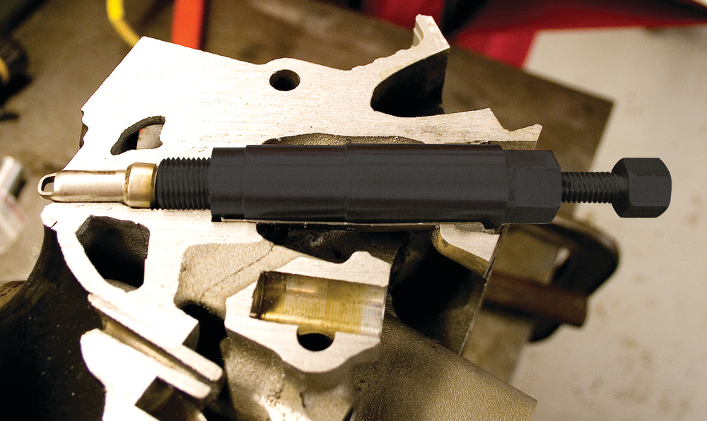 Thread the pusher tool into the spark plug hole, then turn the top screw to push the ceramic down into the sheath.
