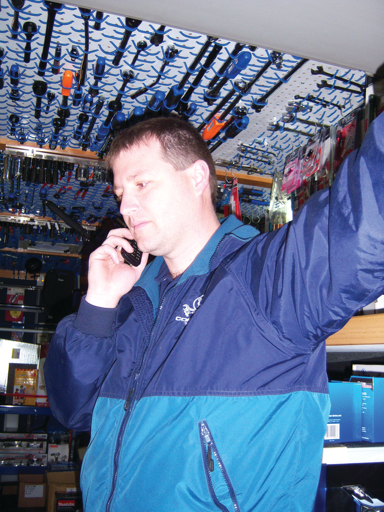 Shane Sutton takes a call from a customer while servicing an account.