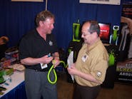 Mike Snider, left, of Legacy Manufacturing shows Ken Seik of Albuquerque, N.M. a fitting for a retractable air hose at the Cornwell Tools tool rally in Dallas, Texas.