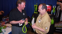 Mike Snider, left, of Legacy Manufacturing shows Ken Seik of Albuquerque, N.M. a fitting for a retractable air hose at the Cornwell Tools tool rally in Dallas, Texas.