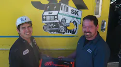 Clint Maxwell, right, gives an Ingersoll Rand air hammer to a customer at a shop that services oil tankers.