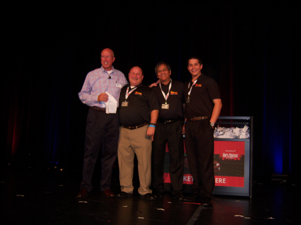 Bruce Weber of ISN, left, honors Jeff Whisen, Manny Occiano and Joshua Carton of Power Probe for having the most exciting booth demos at the trade show.