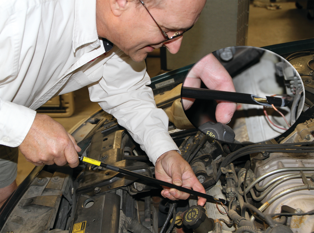 Phil Fournier connects the probe to a wire by piercing the insulation with needles in the end of the brass shaft of the probe.