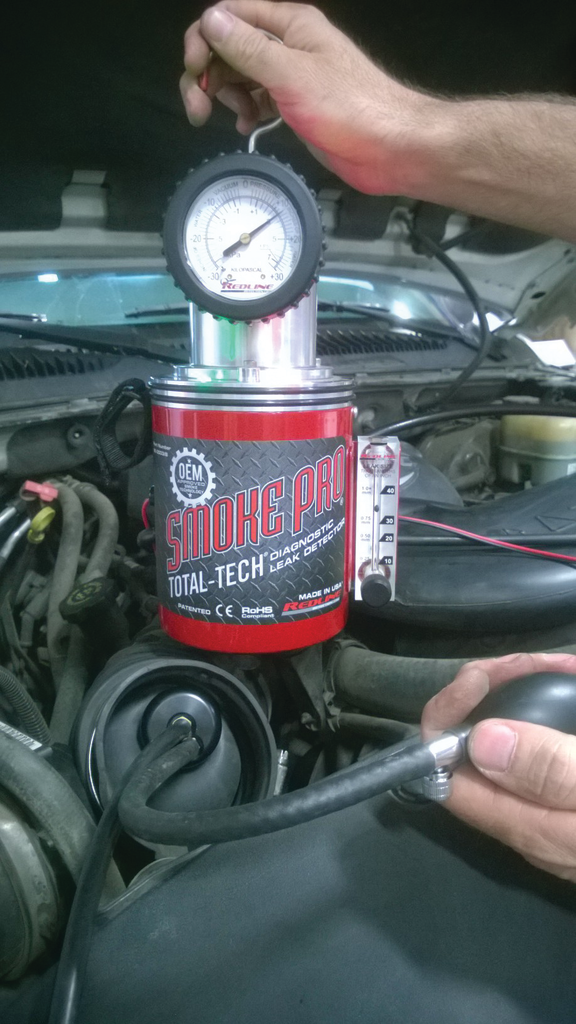 The tech pumps the Redline Easy Intake to seal off the vehicles intake duct and to introduce smoke into the intake system. For more information, go to VehicleservicePros.com/376405