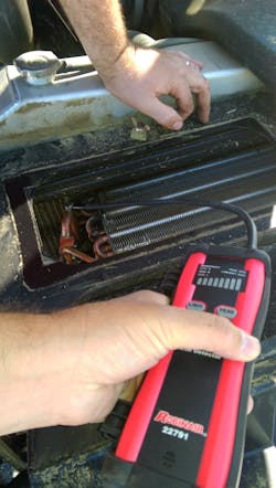 Robert Brocx uses an electronic leak detector on a condenser with a leak. Robert Brocx uses an electronic leak detector on a condenser with a leak.