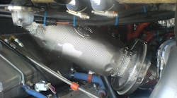 A view of a metal foil insulation blanket over an exhaust bellow within an engine compartment.
