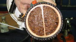 As sludge builds up in diesel fuel, bits of it slough off and travel downstream where they adhere to surfaces – like the bottom of this fuel filter – and start to grow new sludge. As sludge builds up in diesel fuel, bits of it slough off and travel downstream where they adhere to surfaces – like the bottom of this fuel filter – and start to grow new sludge.