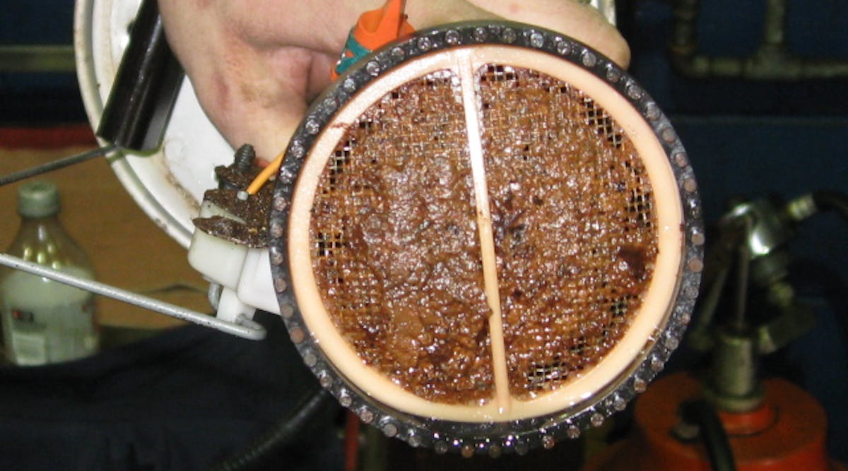 As sludge builds up in diesel fuel, bits of it slough off and travel downstream where they adhere to surfaces &ndash; like the bottom of this fuel filter &ndash; and start to grow new sludge.