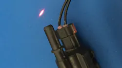 In order to see a small leak, one trick that may work is to dim the lights in the shop and use a laser pointer along the EVAP lines, which will highlight the smoke trail. Here, the laser pointer highlights the leak from an EVAP solenoid.