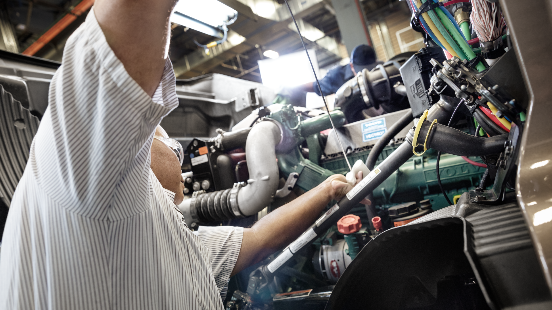 One benefit of cleaner burning diesel engines is less soot output. Here, a technician works on a Volvo D11 engine.