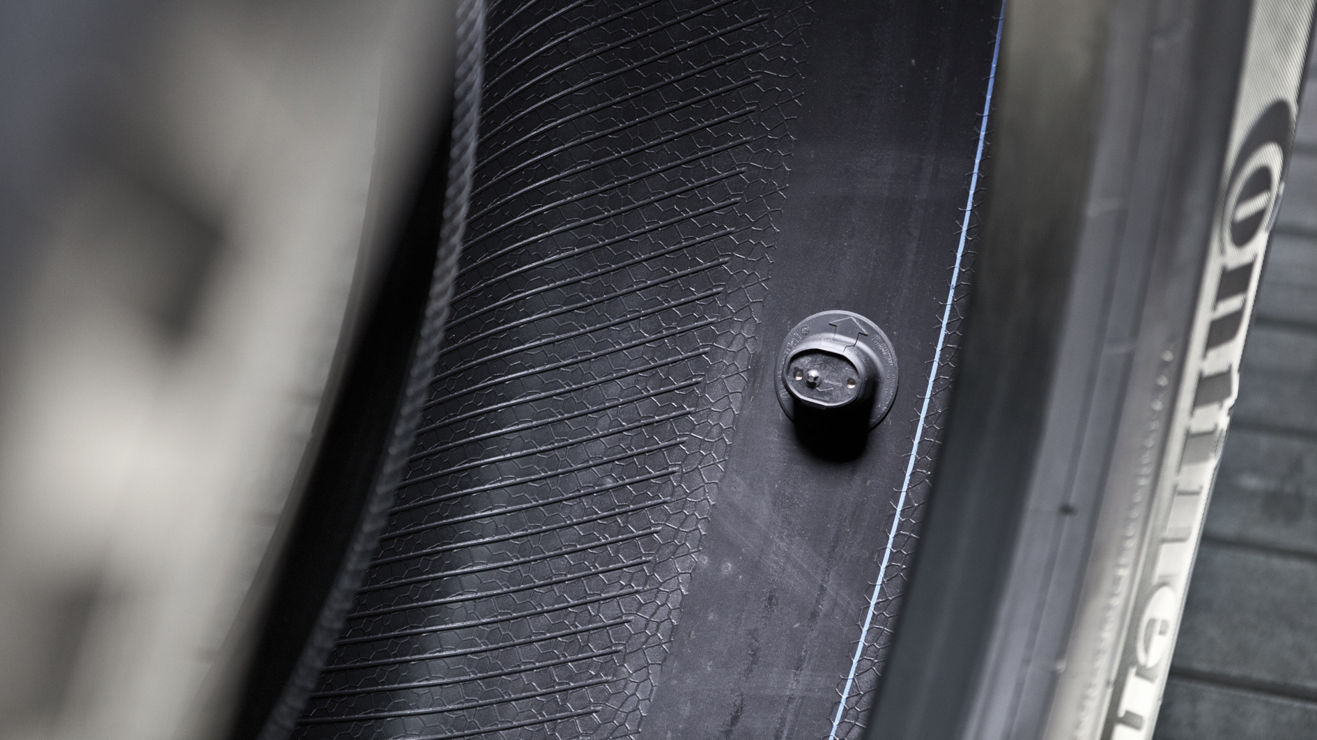 A tire-mounted sensor is adhered to the inner liner of a tire, and delivers tire pressure and temperature data wirelessly to the vehicle or fleet terminal.