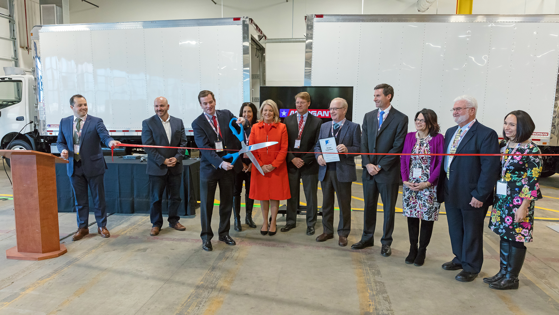 Norb Markert, President and COO of Morgan, cuts the ribbon and marks the official launch of the new facility. Other participants shown, from left to right: State Representative Kevin Skulczyck; Norb Markert, with scissors; State Representative Anne Dauphinais; State Senator Heather Somers; Montie Watson, VP Operations of Morgan; Thomas Sheridan, President of Eastern Connecticut Chamber of Commerce; Adam Winstanley, Principal Winstanley Enterprises, LLC; Plainfield First Selectman, Cathy Tendrich; Paul Sweet, Former Plainfield First Selectman; and Amanda Ljubicic, Vice President of Eastern Connecticut Chamber of Commerce.