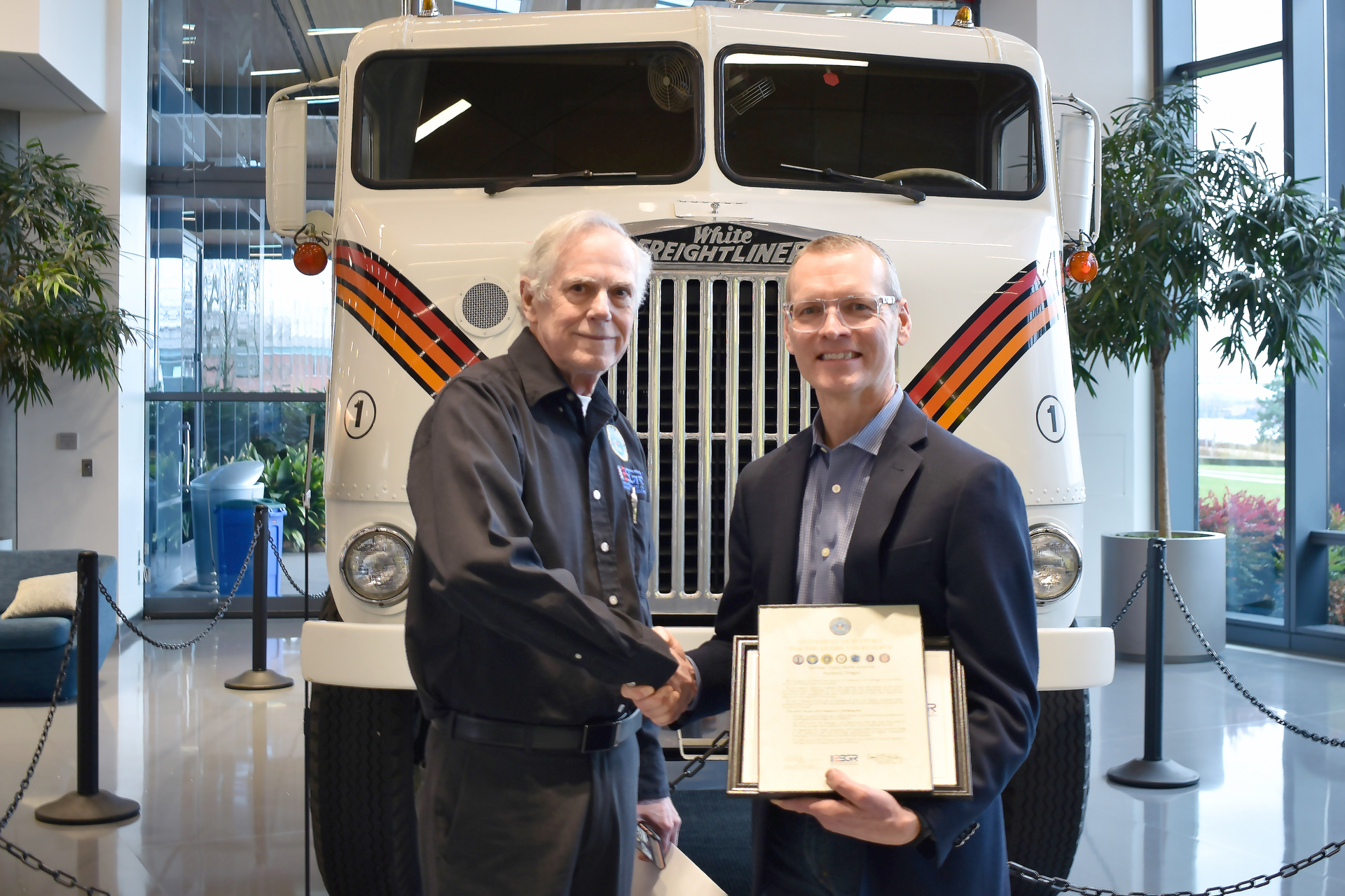 Jeffrey Thompson (right), director of aftermarket supply chain planning, receives the Employer Support for the Guard & Reserve Patriot Award from Bruce Thompson (left).