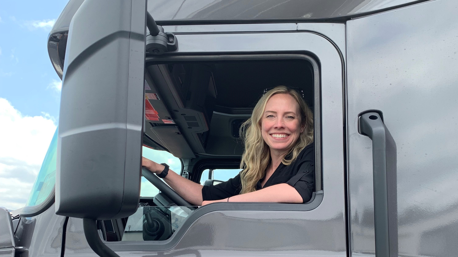 Erica Schueller in the cab of a truck at an media event.