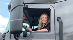 Erica Schueller in the cab of a truck at an media event.