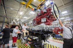 Mack Truck engine plant workers assemble a Class 8 diesel engine. Mack Truck engine plant workers assemble a Class 8 diesel engine.