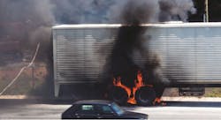 Truck wheels on fire on the side of a highway with firefighters on scene to extinguish the blaze. Truck wheels on fire on the side of a highway with firefighters on scene to extinguish the blaze.