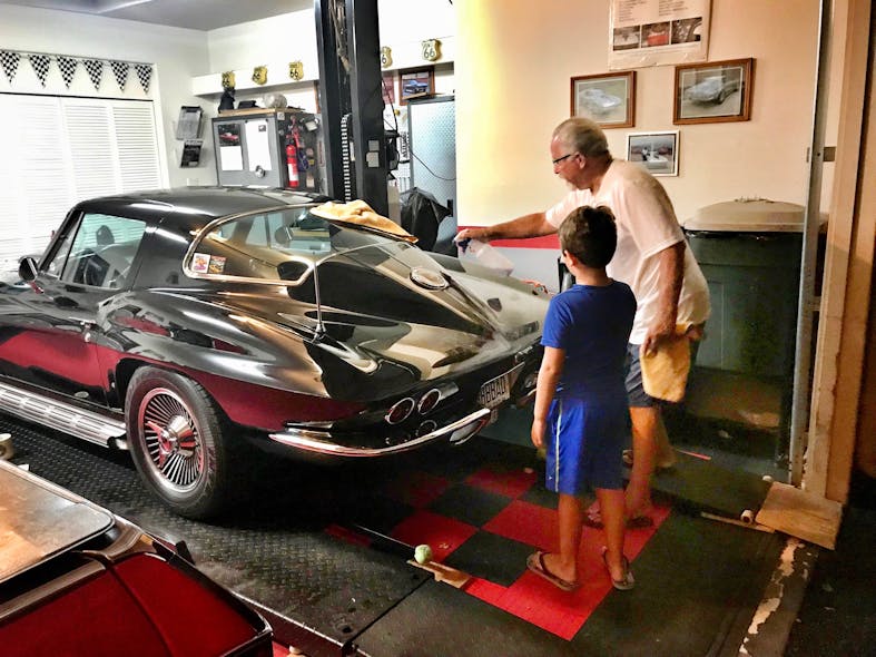 Equipment salesman Lou Cardoza shows his grandson, Aiden, the finer points of lifting his 1966 Corvette at his Hawaii home.