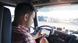A truck driver uses an Eleos Technologies app on a smartphone. Eleos creates custom mobile apps for trucking companies to tailor the work experience for their drivers.