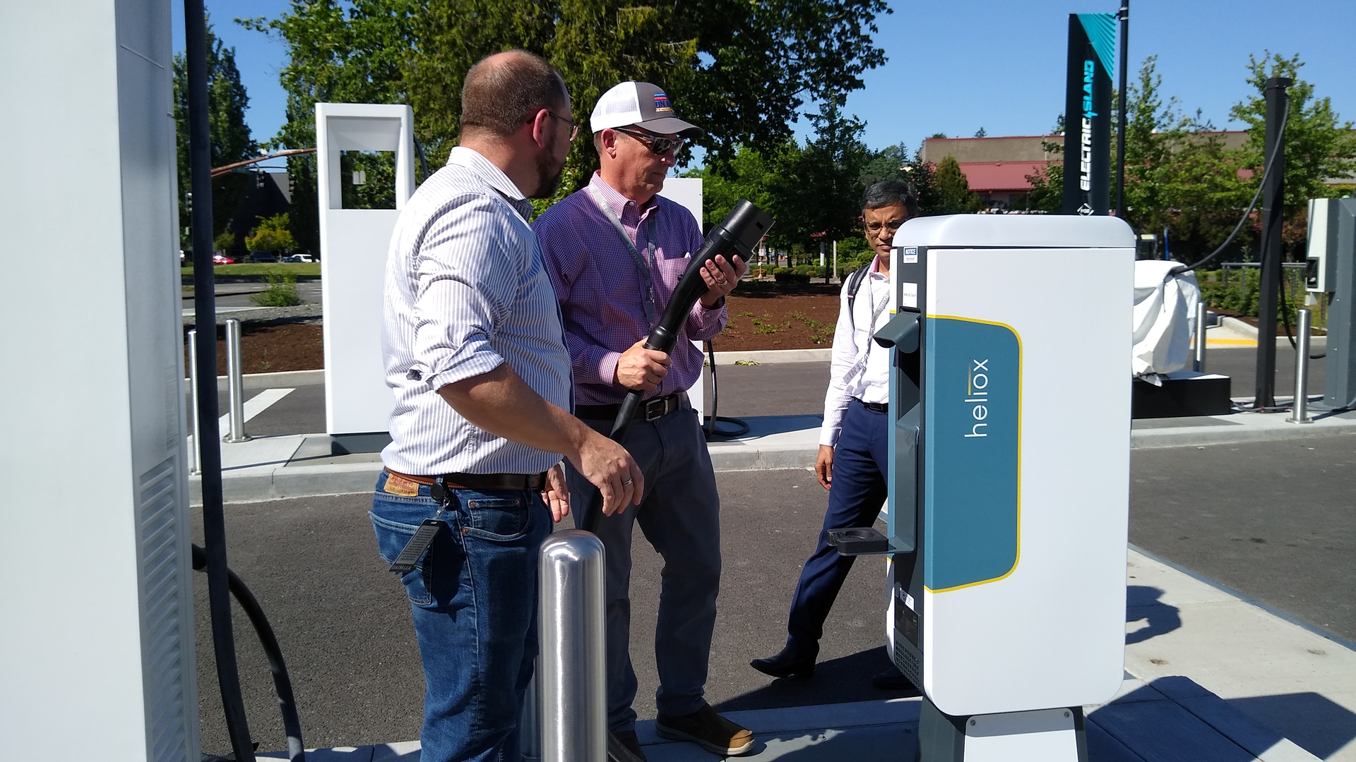 NACFE Executive Director Mike Roeth (center) takes a look at a vehicle charger.