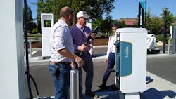 NACFE Executive Director Mike Roeth (center) takes a look at a vehicle charger. NACFE Executive Director Mike Roeth (center) takes a look at a vehicle charger.