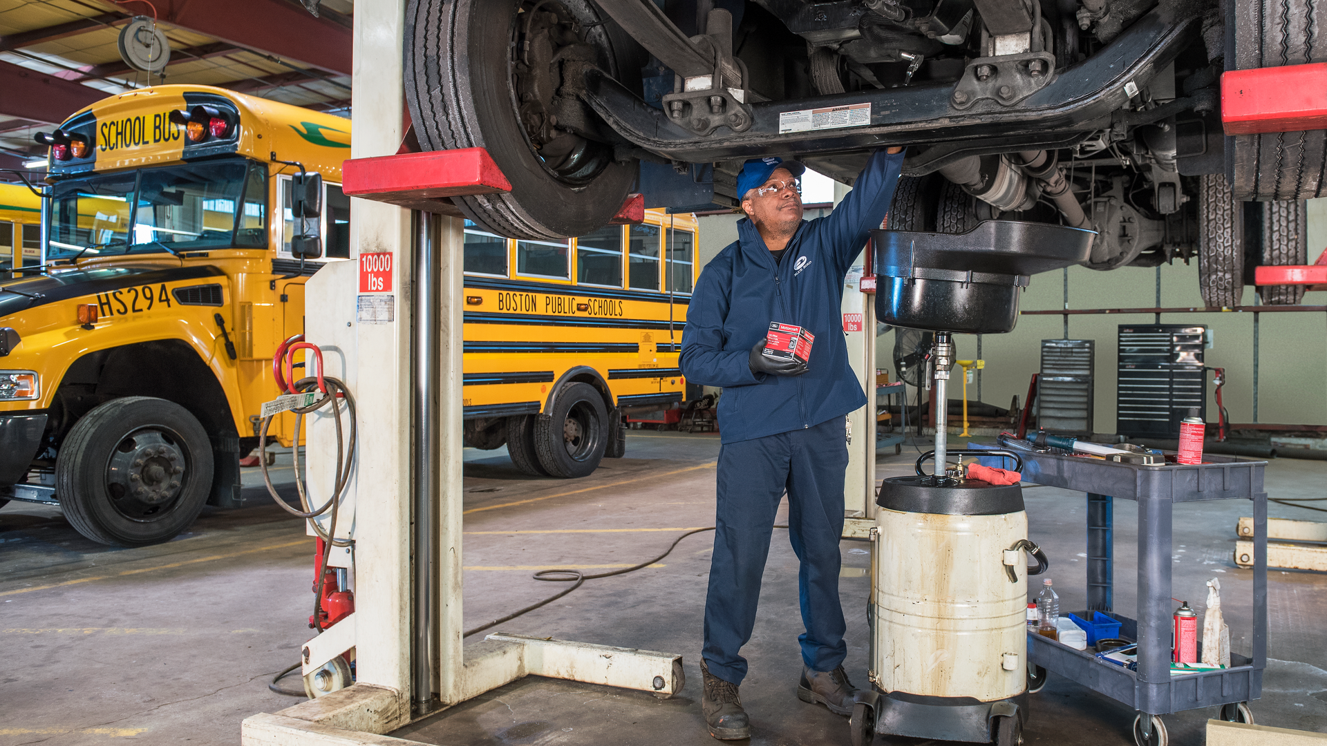 Boston Public Schools' mechanic performs routine maintenance on one of the district's propane buses.