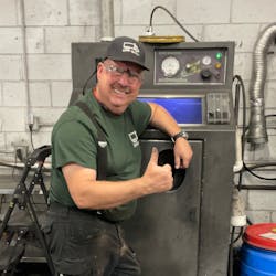 James Wendt of DPF Guys in Atlanta stands next to an EvacuBlast DPF cleaning cabinet in his shop.