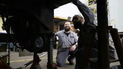 Transport Services technical advisor Mike Conley shows apprentice Dylan Greve how to work on a trailer wheel end. Transport Services technical advisor Mike Conley shows apprentice Dylan Greve how to work on a trailer wheel end.