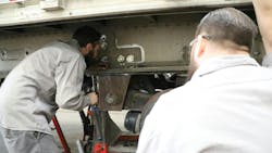 Transport Services technical advisor Mike Conley shows apprentice Dylan Greve how to work on a trailer wheel end. Transport Services technical advisor Mike Conley shows apprentice Dylan Greve how to work on a trailer wheel end.