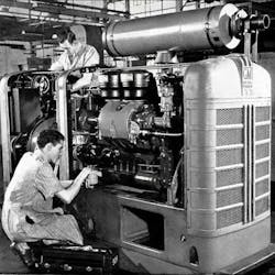 A historic image of workers building a diesel engine at the Detroit Manufacturing Plant. A historic image of workers building a diesel engine at the Detroit Manufacturing Plant.