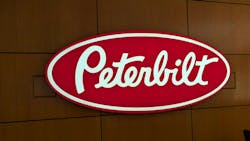 The iconic Peterbilt red oval logo on display in the OEM's Denton, Texas, corporate headquarters. The iconic Peterbilt red oval logo on display in the OEM's Denton, Texas, corporate headquarters.