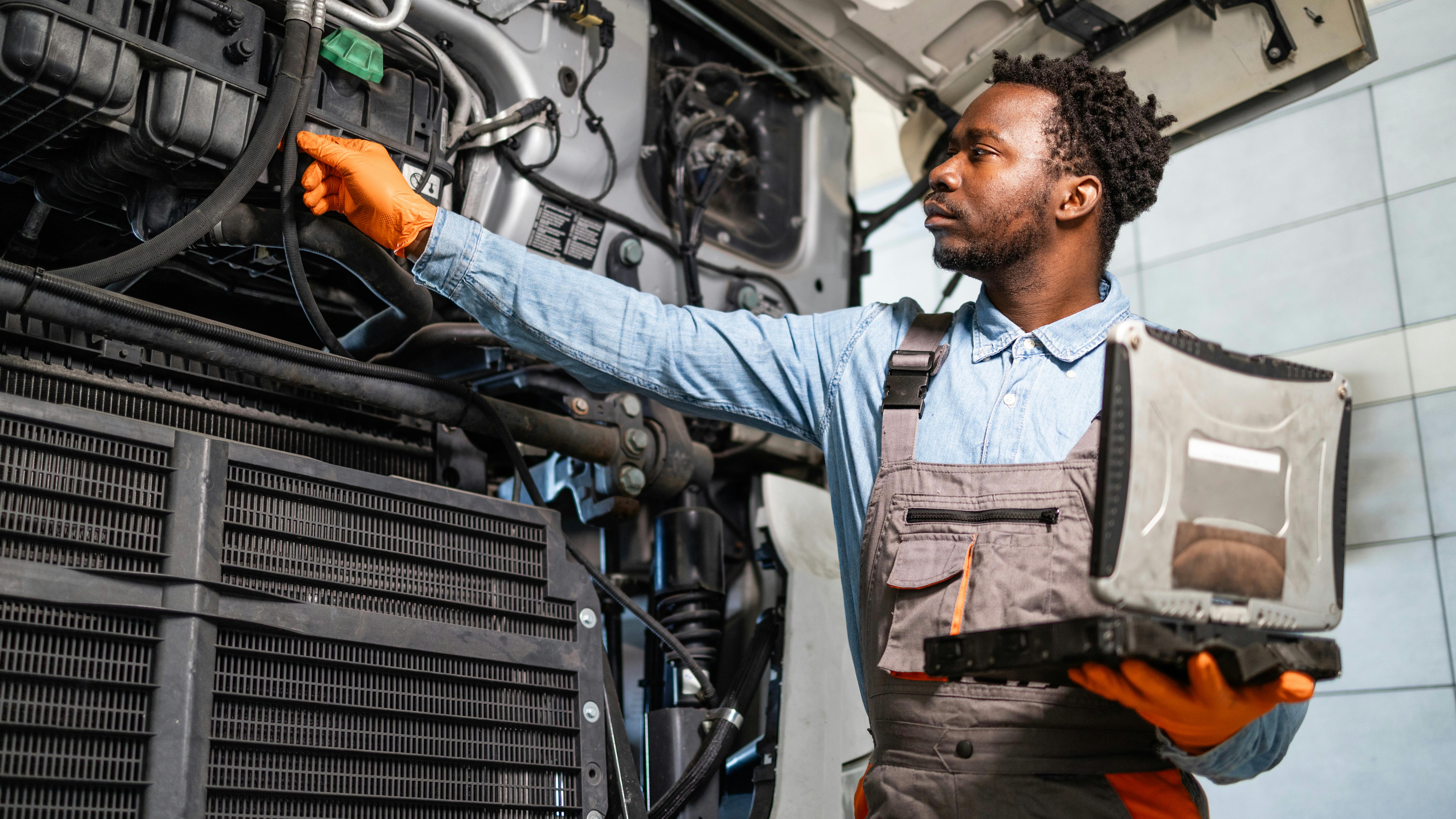 mechanic standing by the truck with hood opened