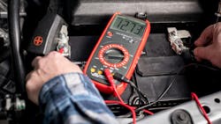 Technician testing truck battery Technician testing truck battery