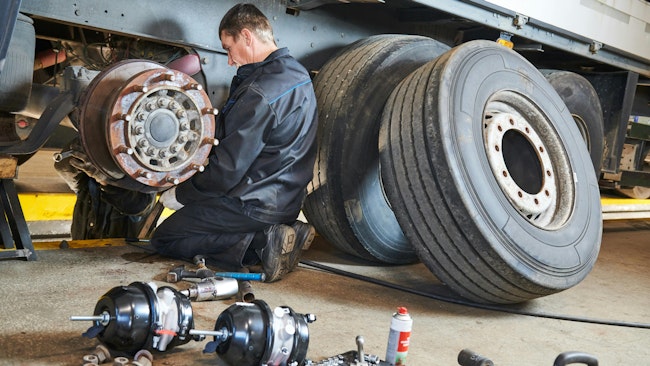 Technician works on semitruck tire