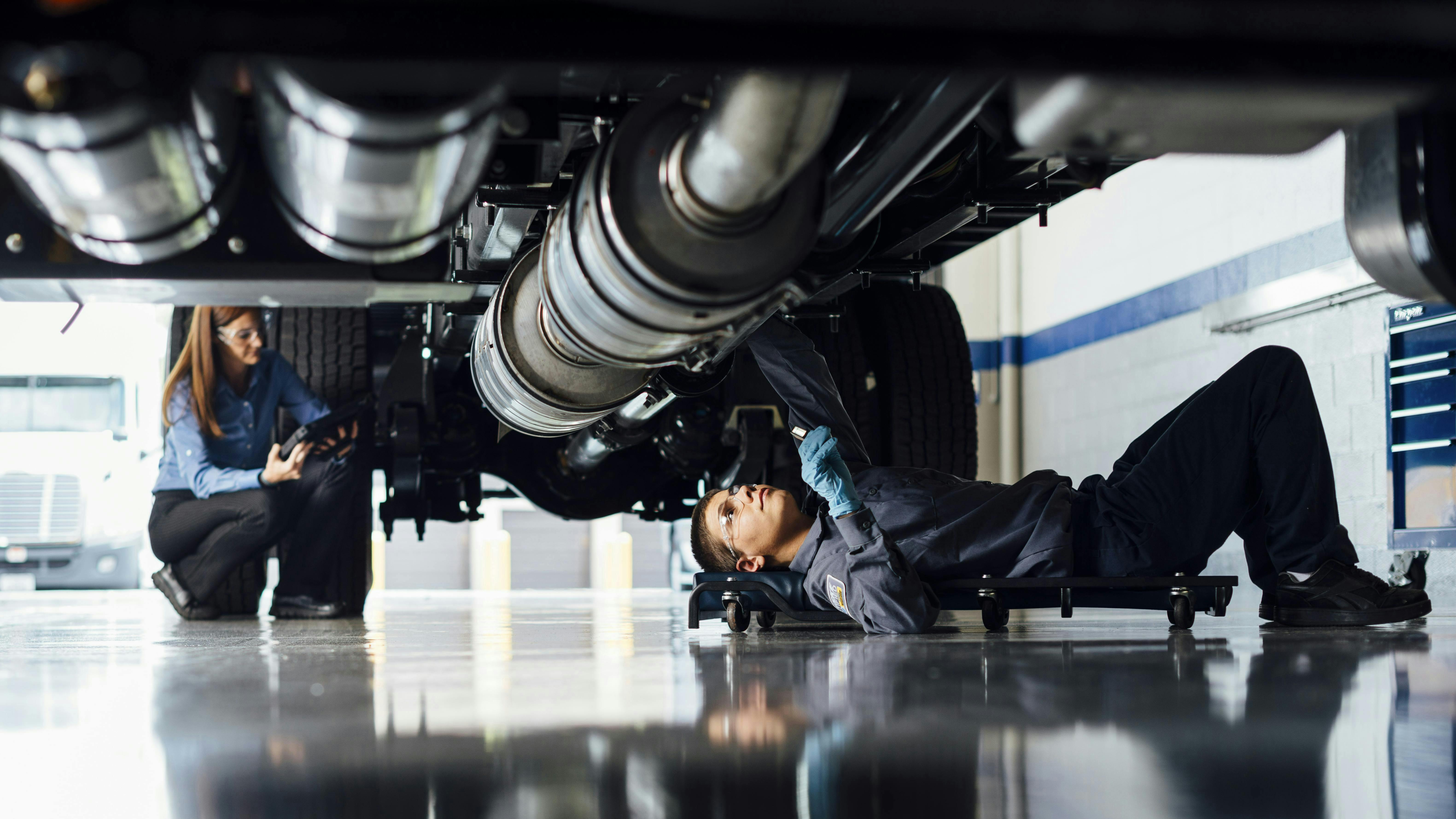 Penske tech inspecting under chassis