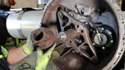 A fault code for “clutch position out of range” or “clutch life remaining” is often triggered by excessive clutch wear or defective components inside the clutch housing. Pictured here is a technician performing a visual inspection of a transmission release bearing.