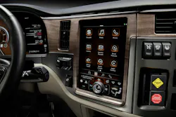 Peterbilt’s variant features a 13' portrait center-stack touchscreen with an innovative 'knob-on-glass' physical dial for controlling HVAC and volume while driving, minimizing driver distraction on uneven roads.